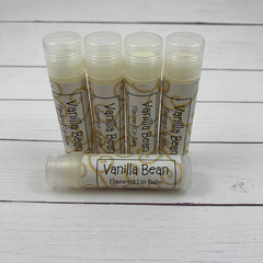 Vanilla Bean lip balm tubes with clear caps, white and gold labels, and text "Vanilla Bean
