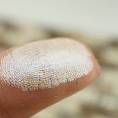 Fingerprint with white powder, showing skin texture and fingerprint ridges on finger