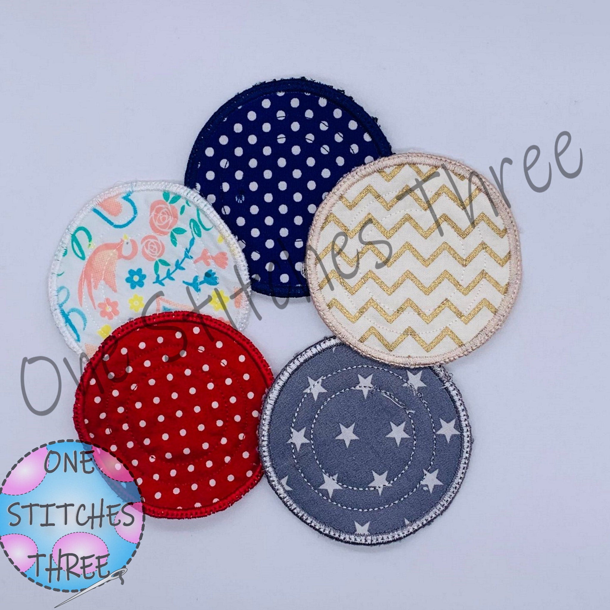 Reusable cotton pads in assorted colors, patterns, and styles, with One Stitches Three logo visible