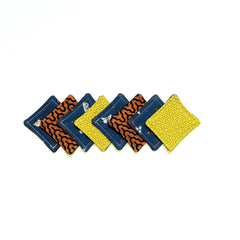 Coasters with various patterns, including geometric, floral, and insect designs in blue, yellow, and orange colors