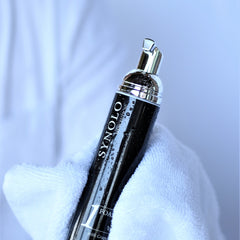 Foam wash bottle, black and silver with water droplets, held in white towel