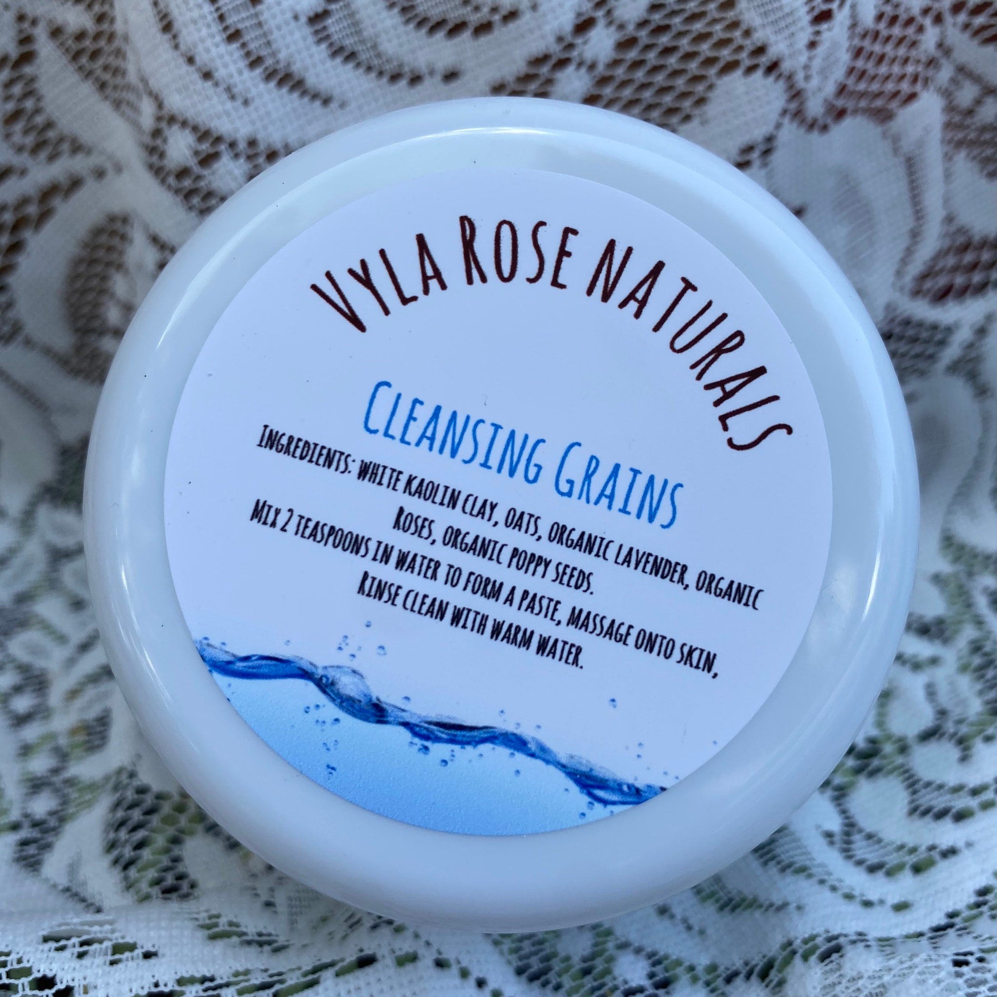 Cleansing grains jar with white label, blue water graphic, Vyla Rose Naturals brand