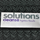 Facial cleanser product with white packaging, purple text, and Avon Solutions brand name visible