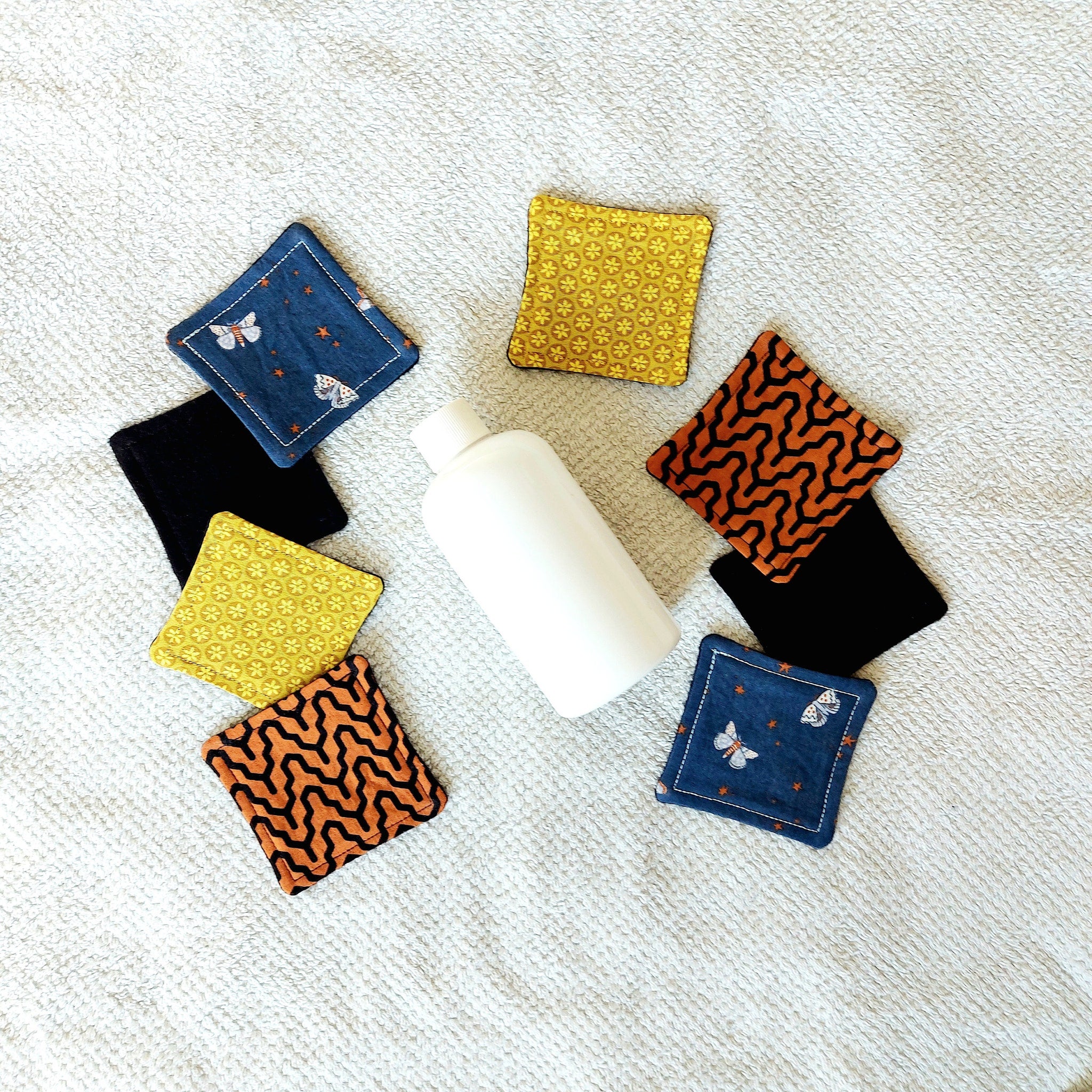 Makeup remover pads with butterfly pattern, various colors, and fabric material on a white towel