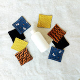 Makeup remover pads with butterfly pattern, various colors, and fabric material on a white towel
