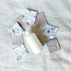 Makeup remover pads, square, leaf print and solid color fabric, with white bottle on towel