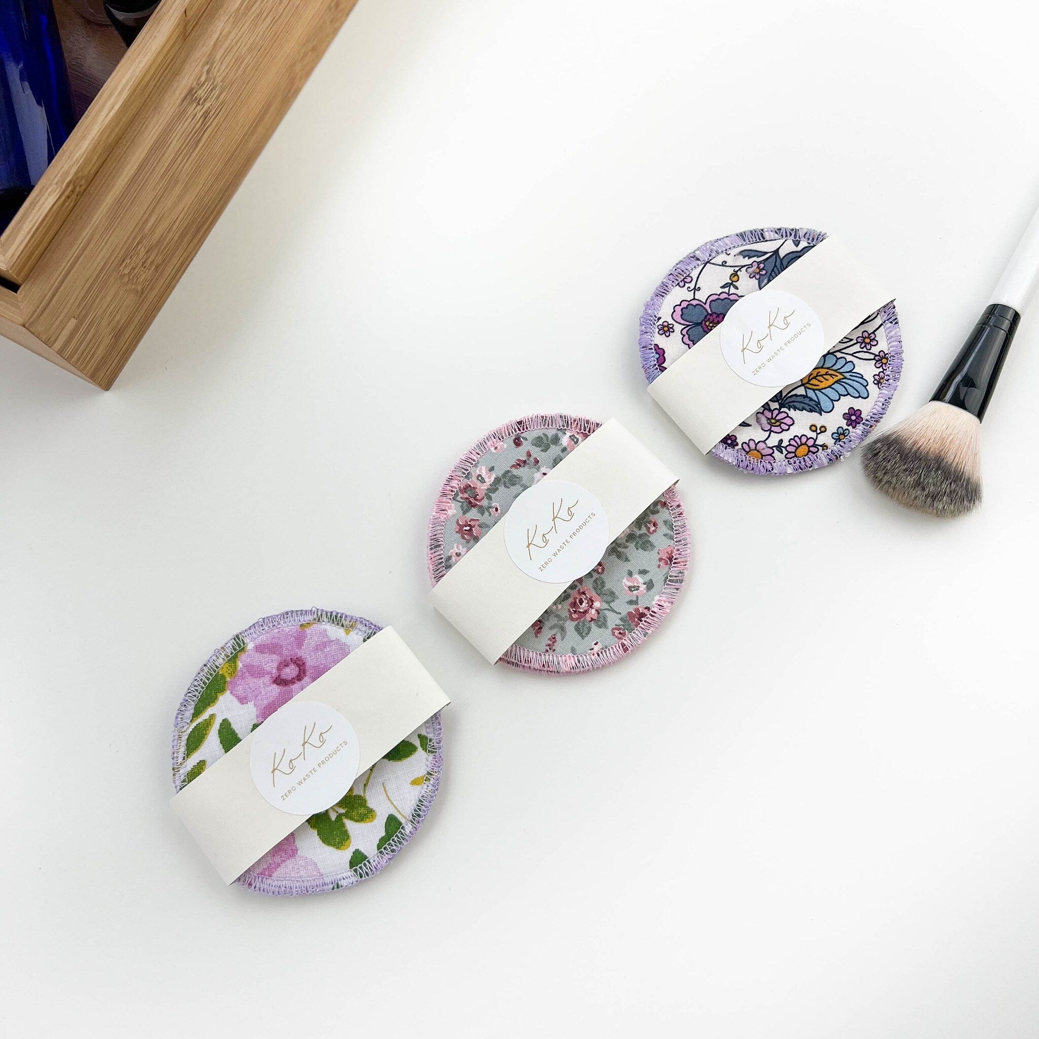 Washable cotton rounds with floral patterns, KOKO brand, white paper wrap on white surface