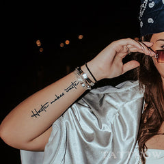 Close-up of semi-permanent tattoo sticker with intricate words sleeve design on skin, showcasing realistic ink detail