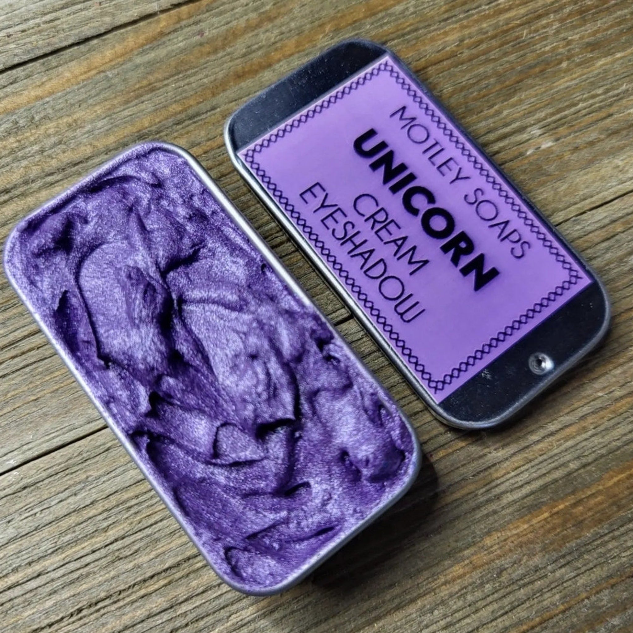 Unicorn-inspired eye shadow palette with pastel pink, purple, and blue shades in a holographic compact