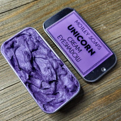 Unicorn-inspired eye shadow palette with pastel pink, purple, and blue shades in a holographic compact