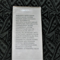 Ingredients list on white rectangular label, with black text, against a dark patterned background