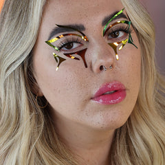 Eye makeup with metallic gold, green, and brown accents on model's face