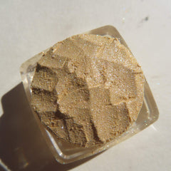 Glitter eyeshadow, gold shimmer, textured powder, in clear square container