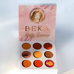 Woman applying shimmering taupe eyeshadow with a fluffy brush from the 4-piece palette