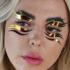 Eye makeup with gold and green metallic accents applied to model's eyes