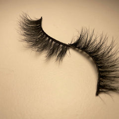 False eyelashes with black synthetic fibers and curved style on beige background
