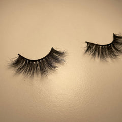 False eyelashes, black synthetic fibers, curved style, on beige surface