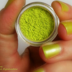 Side view of vibrant lime green eyeshadow pan with smooth matte finish in minimalist eco-friendly packaging