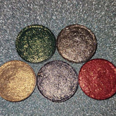 Close-up of Holiday Sparklers Eye Shadow palette with shimmering gold, emerald, and ruby shades in sleek black compact