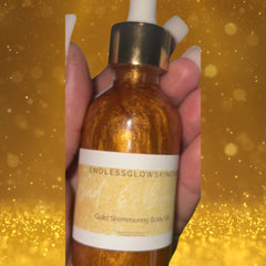 Luxury gold glass bottle of shimmering 24K body oil with elegant black dropper and minimalist label