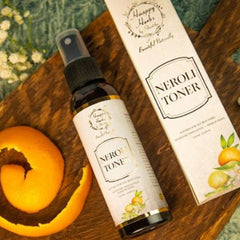 Neroli facial toner bottle with black cap and white label, Haappy Herbs branding on wooden surface