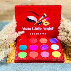 Close-up of fingertips applying shimmery teal eyeshadow from palette to eyelid with blending brush