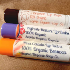 Lip balms, three tubes with colored caps and white labels, Sophia Organic Soap Co. visible