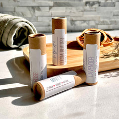 Lip balm tubes in brown cardboard with white labels, Le Bon Amor brand visible