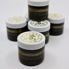 Antifungal balm in brown glass jar with white lid, gold label, and Gleam & Glow branding
