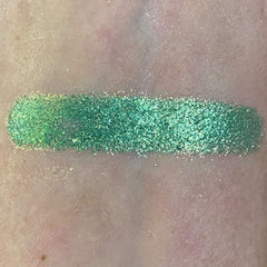 Side view of fir green pressed powder eyeshadow in compact palette showing shimmer finish