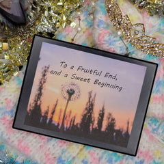 Framed print with black frame, sunset scene, and inspirational text on a colorful knitted surface