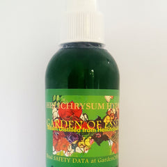 Green glass bottle with white cap, Garden of Essences label with floral design