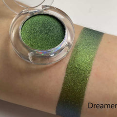 Green eyeshadow in clear compact with swatch on arm, "Dreamer" text visible