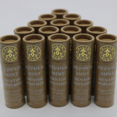 Lip balm tubes in brown cardboard with gold logo and text, arranged in a triangle formation