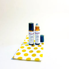 Lip oil bottles with black and brown caps, white labels, and Divine Skin branding, on a polka dot paper