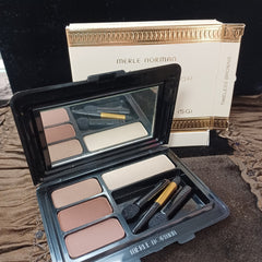 Eyeshadow palette with neutral shades, black compact, and Merle Norman brand name visible