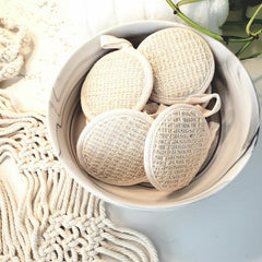 Loofah scrubbers, natural woven texture, cream color, in bowl