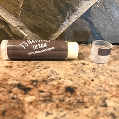 Lip balm tube with brown and white label, clear cap, and text "J's Naturals Lip Balm