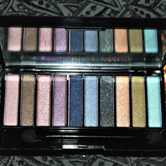 Side view of vintage Avon Luxe clutch eyeshadow compact showing gold-trimmed edges and textured pattern