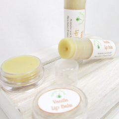 Lip balm with yellow color, clear container, and "Vanilla Lip Balm" label on white surface