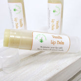 Lip balm tube with white and gold label, light yellow balm, and clear plastic tube