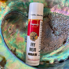 Lip balm tube with red and white label, "Originals" text, and Fry Bread Grease printed on it.