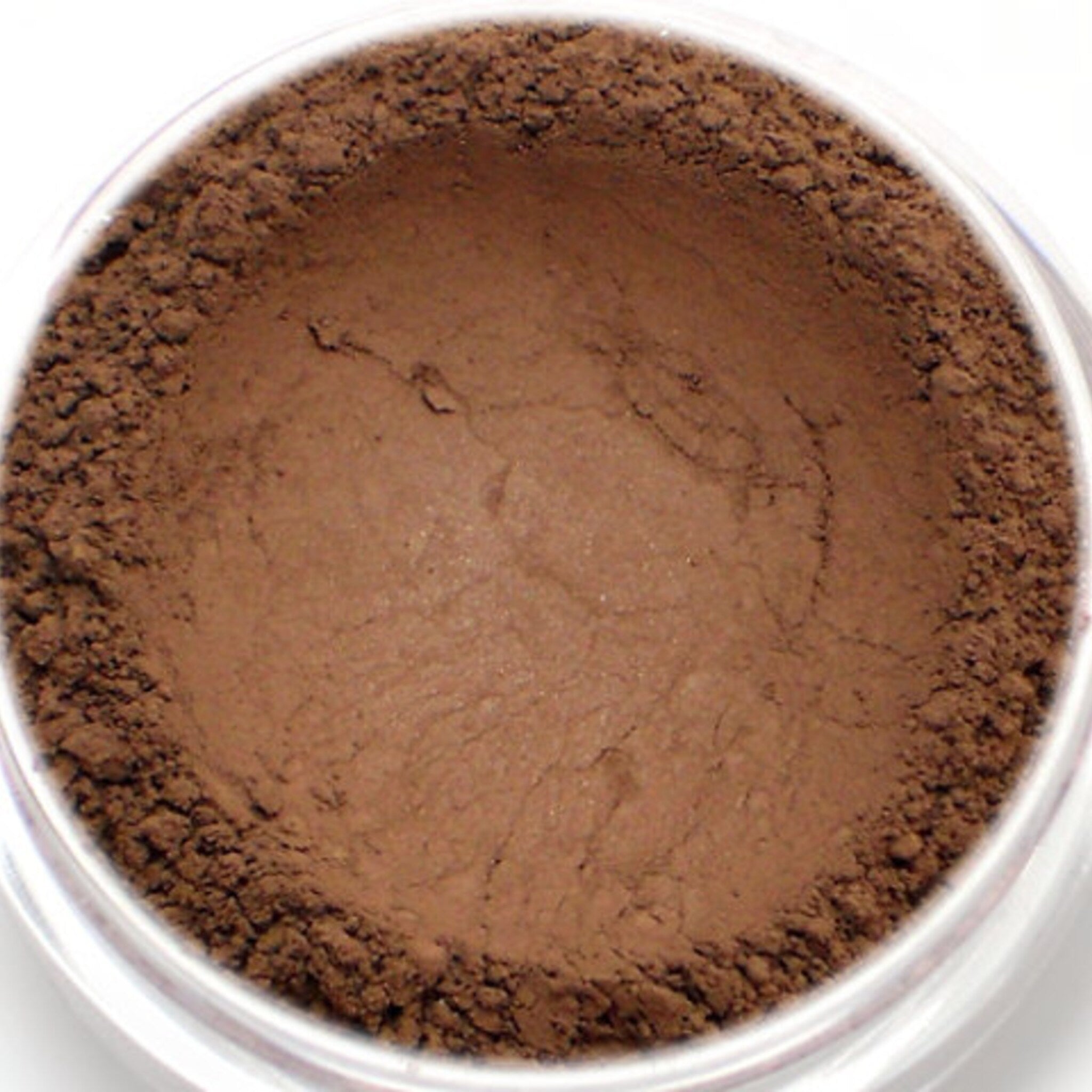 Eyeshadow powder, matte dark brown color, close-up view in clear jar
