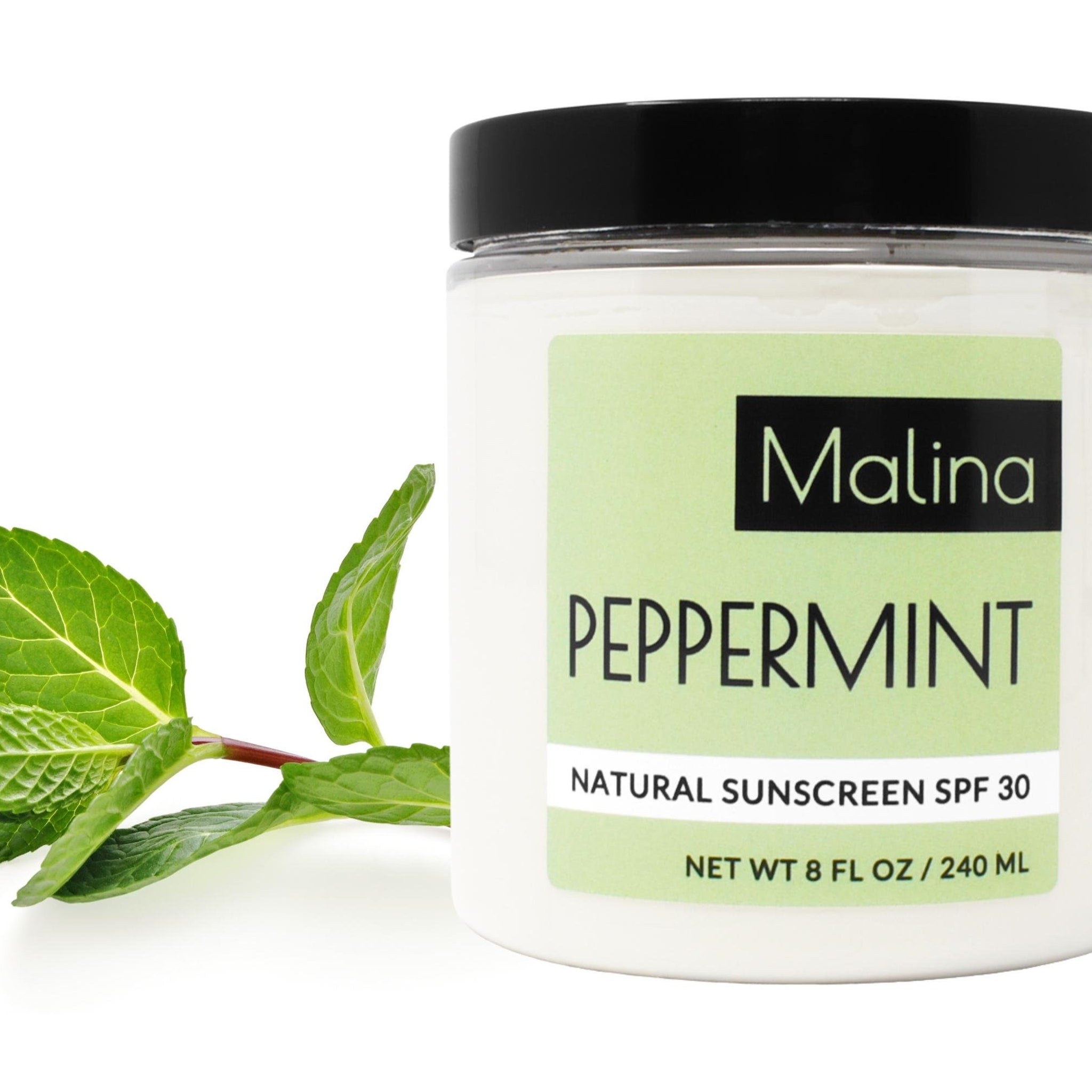 Natural sunscreen jar with black lid, white label, and green mint leaves, Malina New York