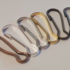 Metal safety pins in various colors, including silver, gold, and bronze, in a row