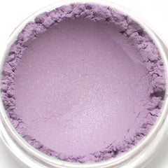 Purple powder eyeshadow in a clear container, with a shimmery finish and textured edges
