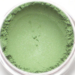Side view of shimmery pistachio green eyeshadow pan with soft metallic finish in compact case
