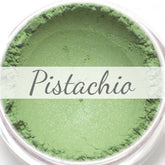 Close-up of shimmery pistachio green vegan eyeshadow in compact with reflective finish