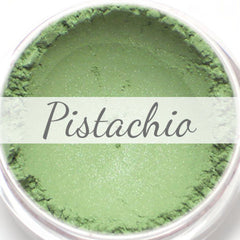Close-up of shimmery pistachio green vegan eyeshadow in compact with reflective finish