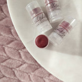Lip balm, elderberry tinted, clear plastic tubes, BasswoodBeauty branding visible